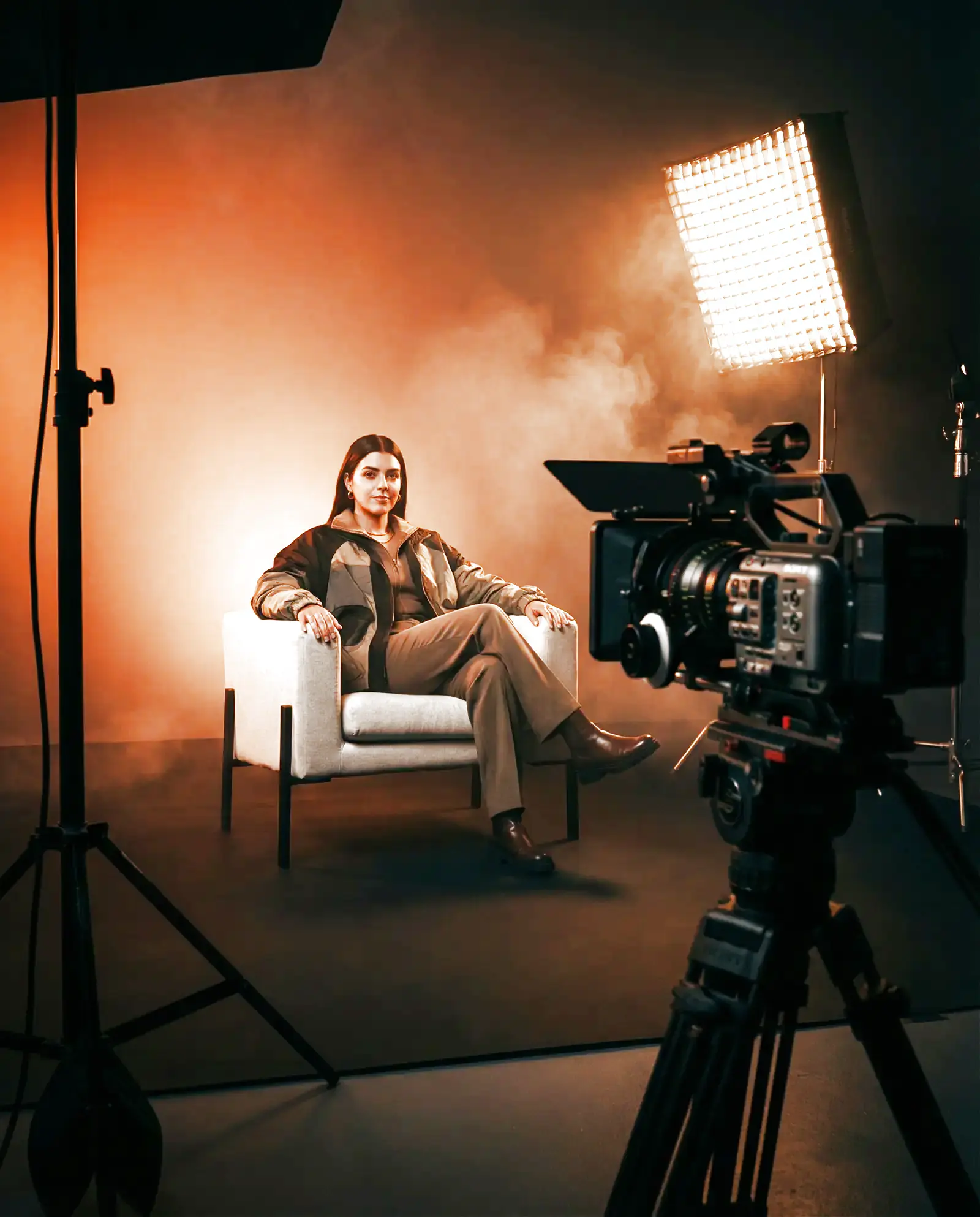 A model on a lit studio set with a cinema camera in the foreground