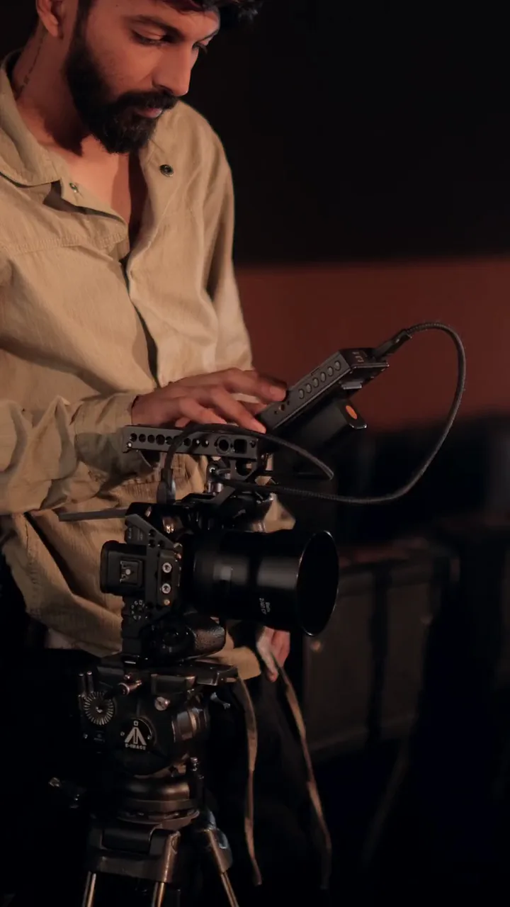 A camera operator lining up a shot inside the cinema during the Karpagam Grandplex shoot